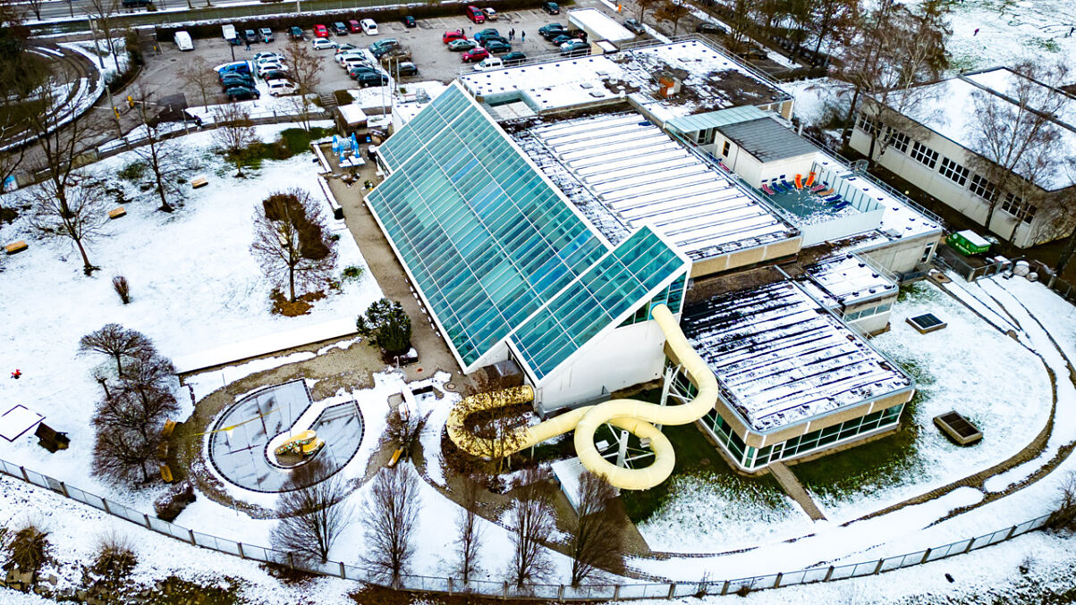Hallenbad mit Wasserrutsche und Parkplatz im Schnee, Wien
